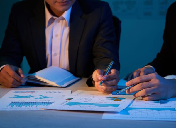 Close-up image of coworkers discussing financial charts at business meeting